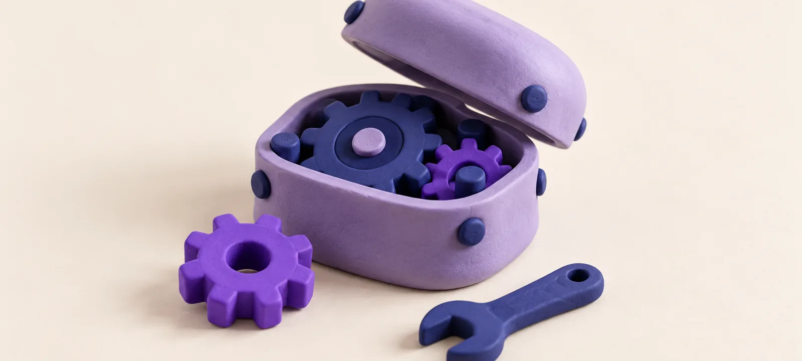 An open lavender clay gearbox with one violet cog taken out and lying beside a small clay wrench: finding the part that stopped working