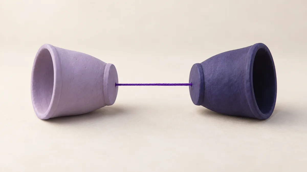Two clay cups joined base to base by a taut string, like a cup-and-string toy — a one-to-one DM, not a pitch
