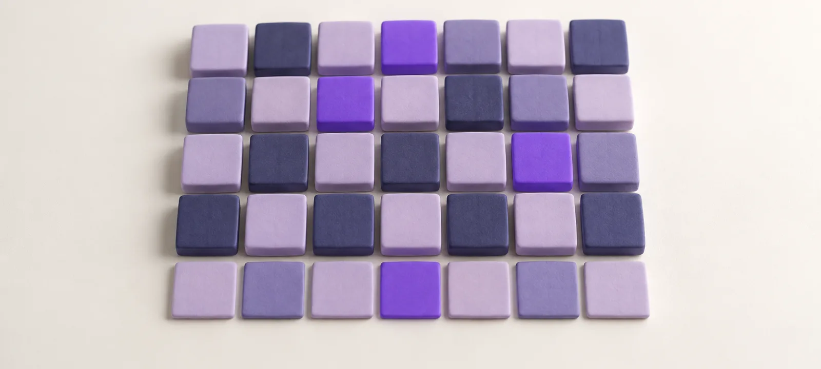 A grid of thirty-five square clay tiles in five rows of lavender and indigo shades, a few in bright violet, like a month of days