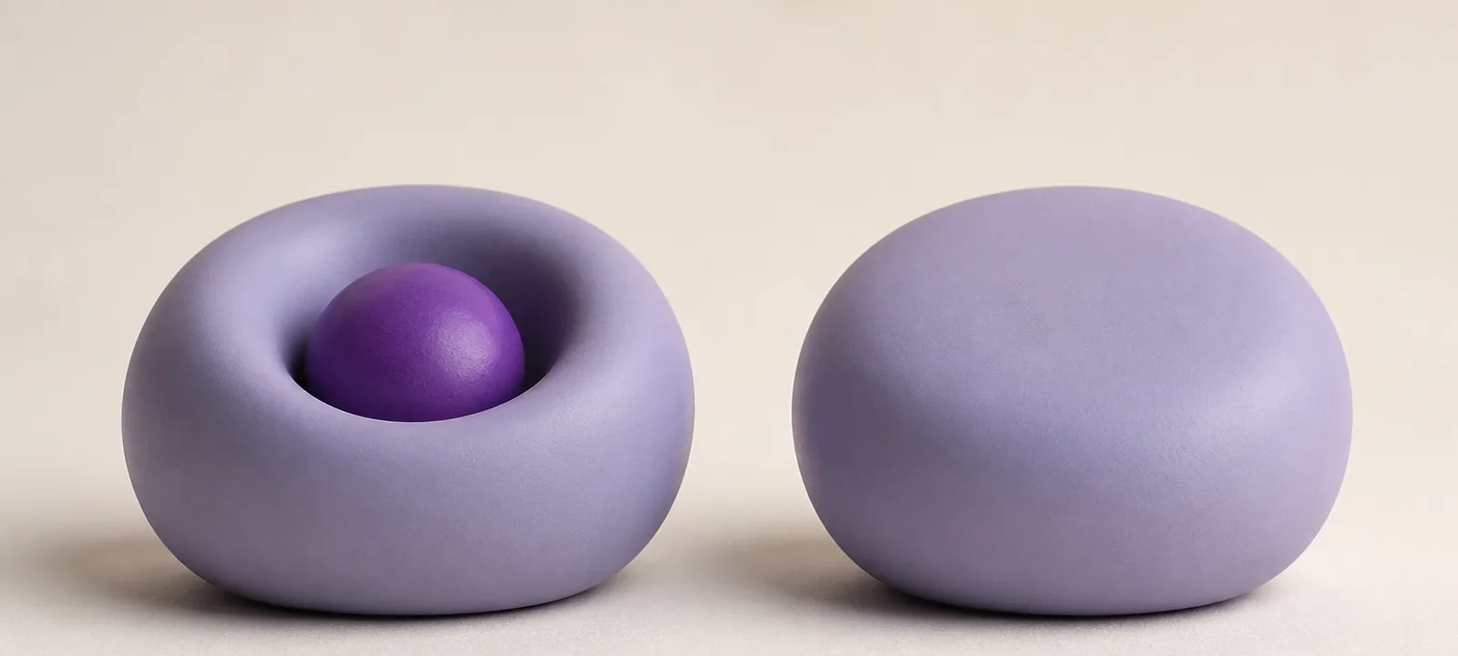 Two matte clay forms side by side: the left holds a smaller second form nested visibly inside a shallow recess, the right is solid and unbroken